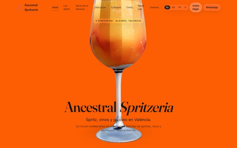 Portada de ancestralbar.es en escritorio: copa de spritz sobre fondo naranja, menú de navegación y selector de idioma.